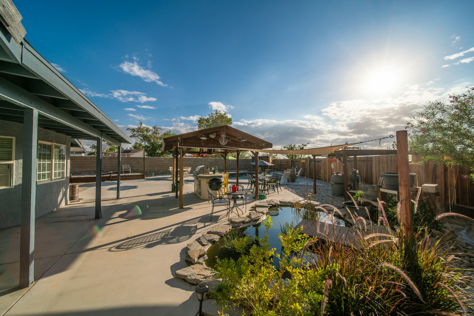 Transformed Arizona backyard with covered patio, pool, and desert landscaping at golden hour