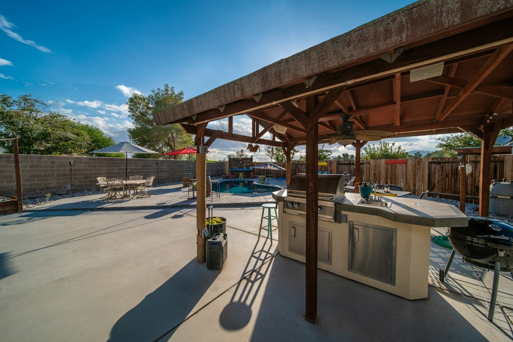 Outdoor kitchen and shaded ramada with paver patio
